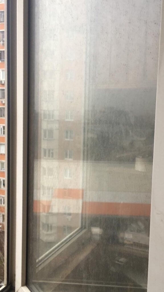 Очень грязное стекло окна с видом на многоэтажку